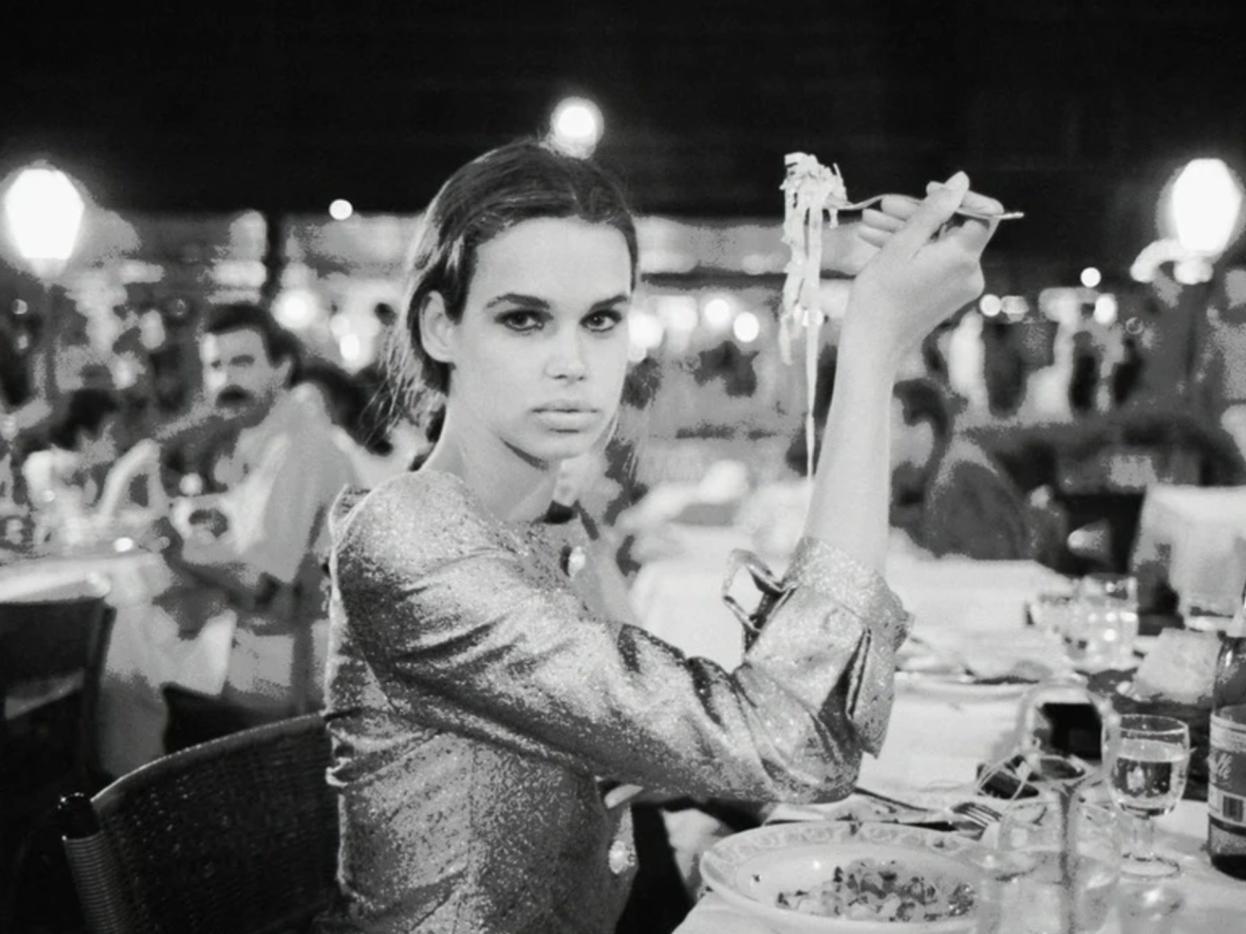 Black-and-white photograph of a diner enjoying pasta