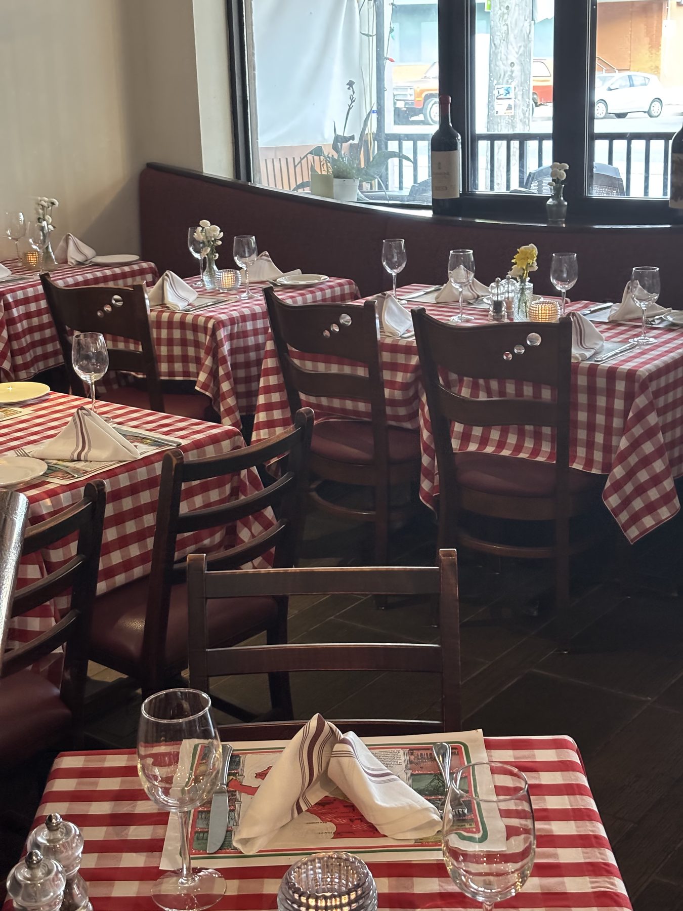Casa Di Giorgio's warm dining room with red-checked tablecloths by the window